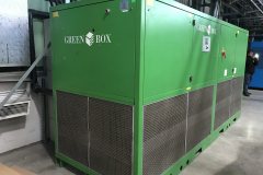 Widoczny agregat chłodniczy Green Box, element przemysłowych instalacji chłodniczych, rurociągi i pompy w trakcie montażu.