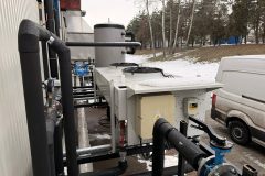 Instalacja przemysłowa wody lodowej z rurociągami, pompami i agregatami, widoczny montaż i podłączenia systemu chłodzenia.