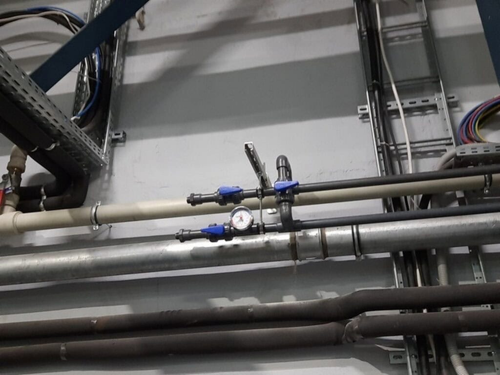 Przewody i zawory instalacji chłodzenia wodą lodową w industrialnym układzie chłodniczym.