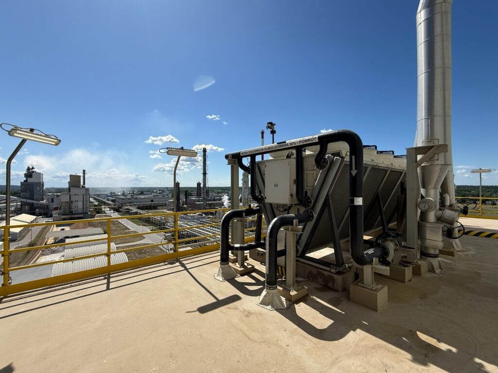 Dobór dry coolera do instalacji glikolu na dachu zakładu produkcyjnego, w tle hale i kominy
